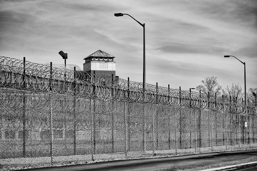 Grayscale photo of fencing around a prison yard