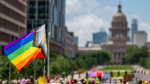 Protest for LGBTQ+ rights, flag waving over a field of people