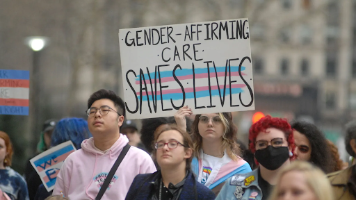 Photo: protesters in a group, one holding a sign that says 