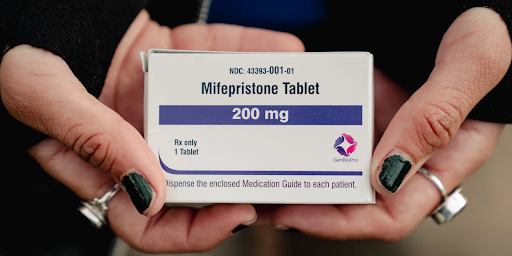 Photo of a packet containing Mifepristone tablet, held by a person