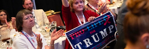 A woman holds a sign as she listens to former U.S. President Donald Trump speak at the North Carolina Republican Party Convention in Greensboro on June 10, 2023