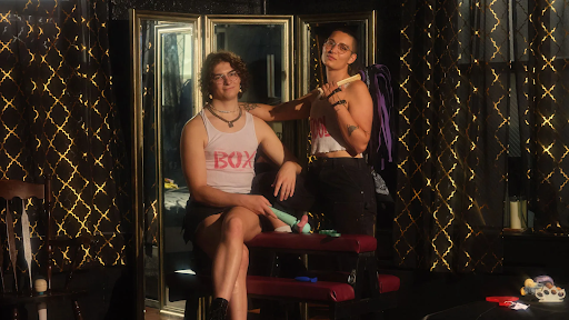 Photo: Artemis and Grace in their dungeon space, surrounded by black and gold curtains