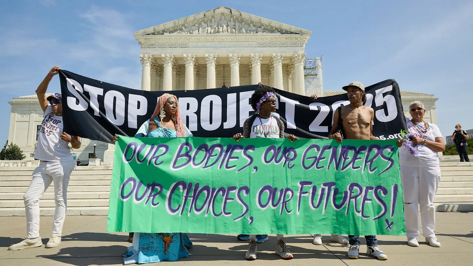 A group of people on the steps of the Supreme Court building holding banners.